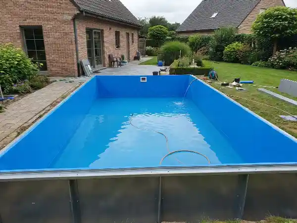 Zwembad met stalen panelen en nieuwe blauwe liner tijdens het vullen