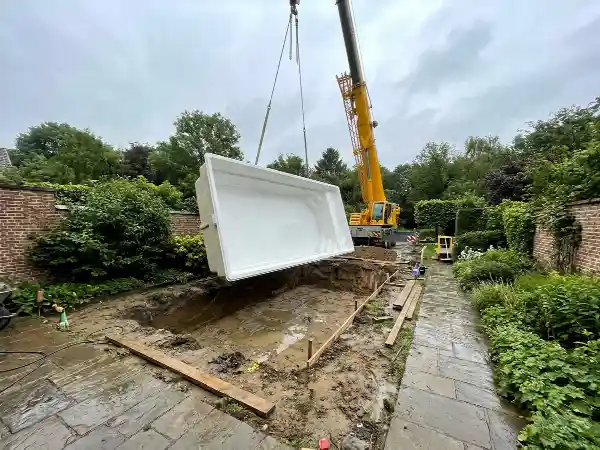 Polyester monoblok dat met een kraan in de uitgraving zakt